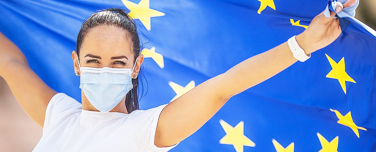 eu europees europese unie union vlag blauw gele sterren vrouw meisje blank mondkapje zwaaien