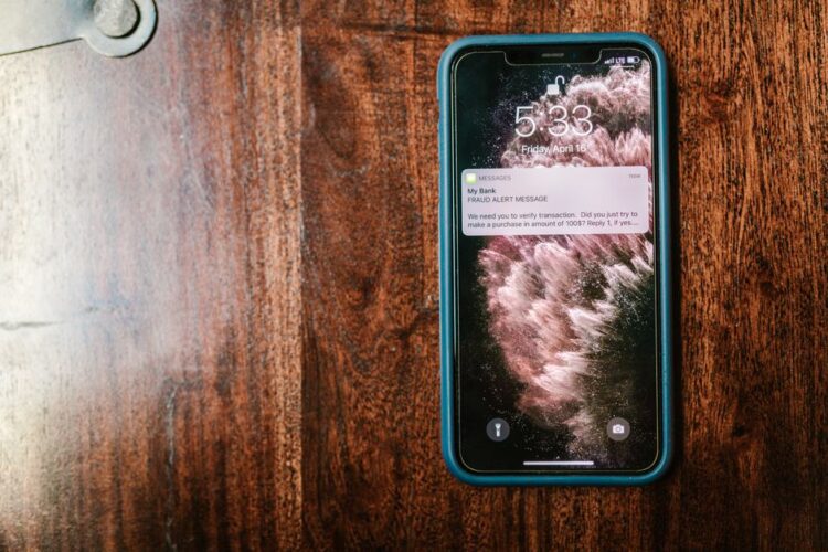 Smartphone op een houten tafel met een vals waarschuwingsbericht over een betaling