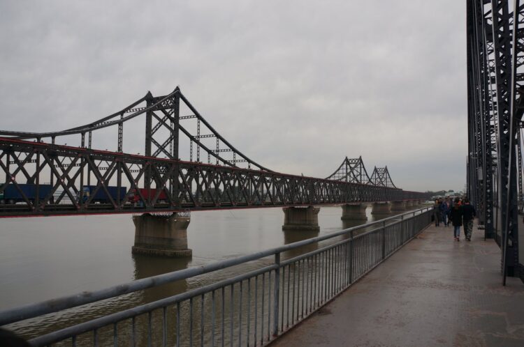 De oude Chinees-Koreaanse Vriendschapsbrug over de Yalu, gezien vanaf de kade in Dandong