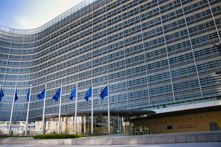 Het Berlaymontgebouw van de Europese Commissie in Brussel met een rij EU-vlaggen